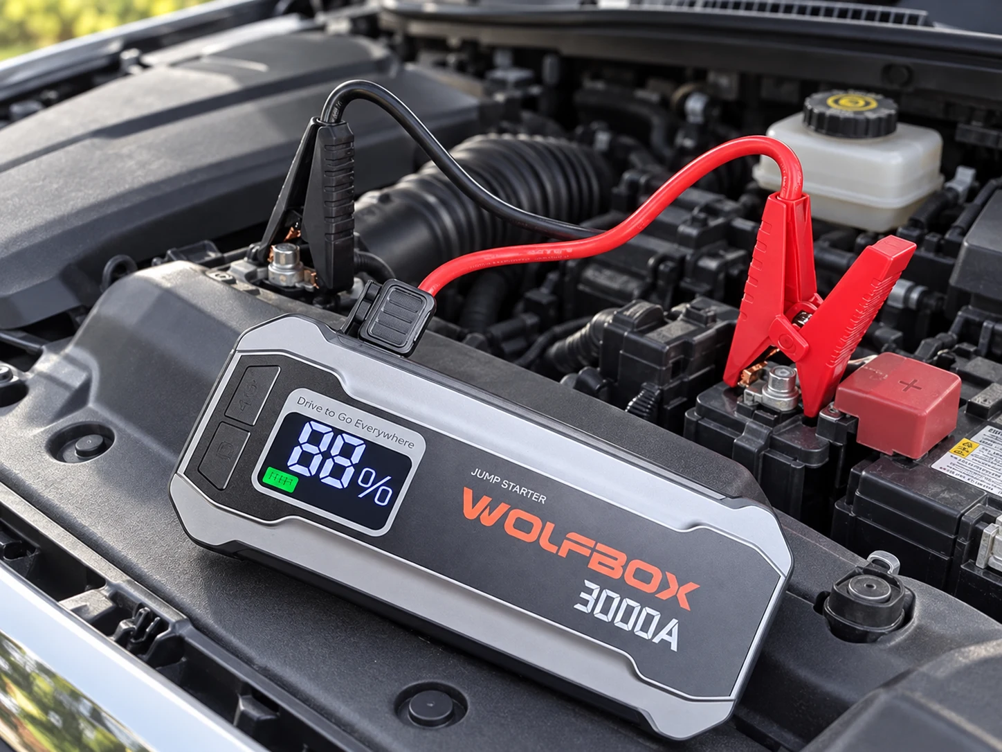 WOLFBOX MegaVolt16 connected to a vehicle battery in an engine bay